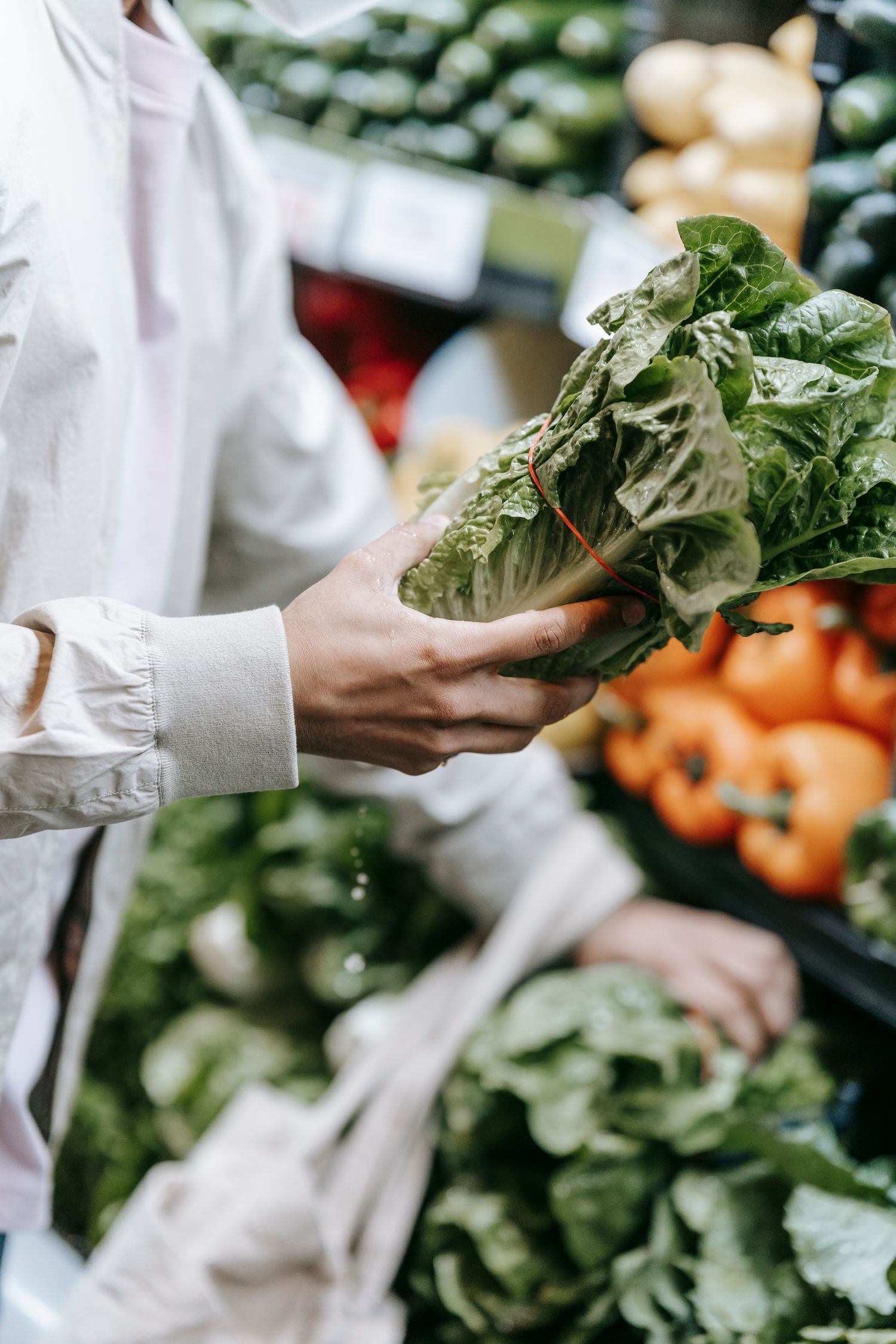 Cliente escolhendo verduras frescas na banca do Hortifrúti da Praça